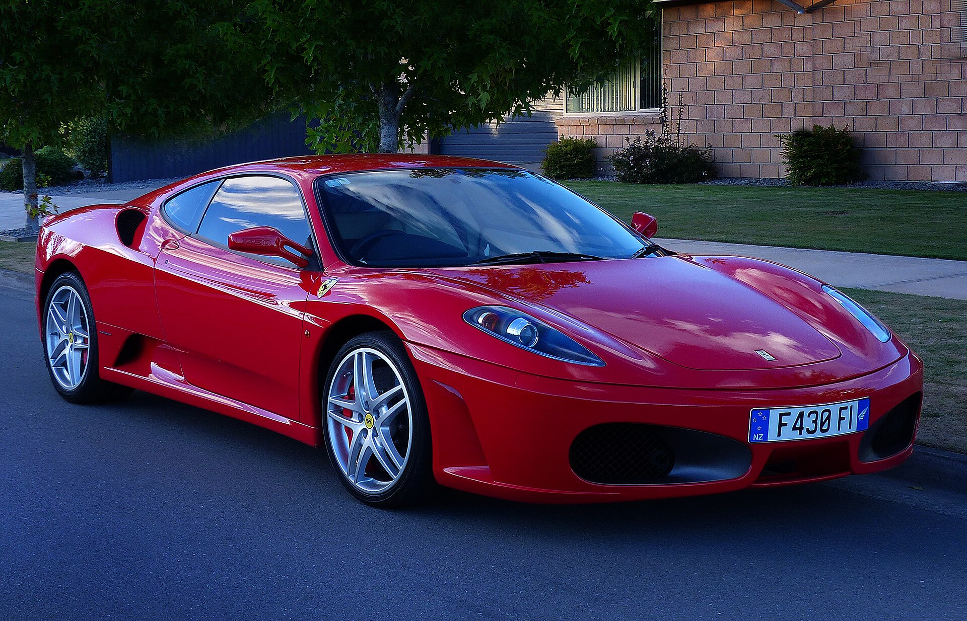 Red 2006 Ferrari F430 Berlinetta F1 coupé viewed from the front side.