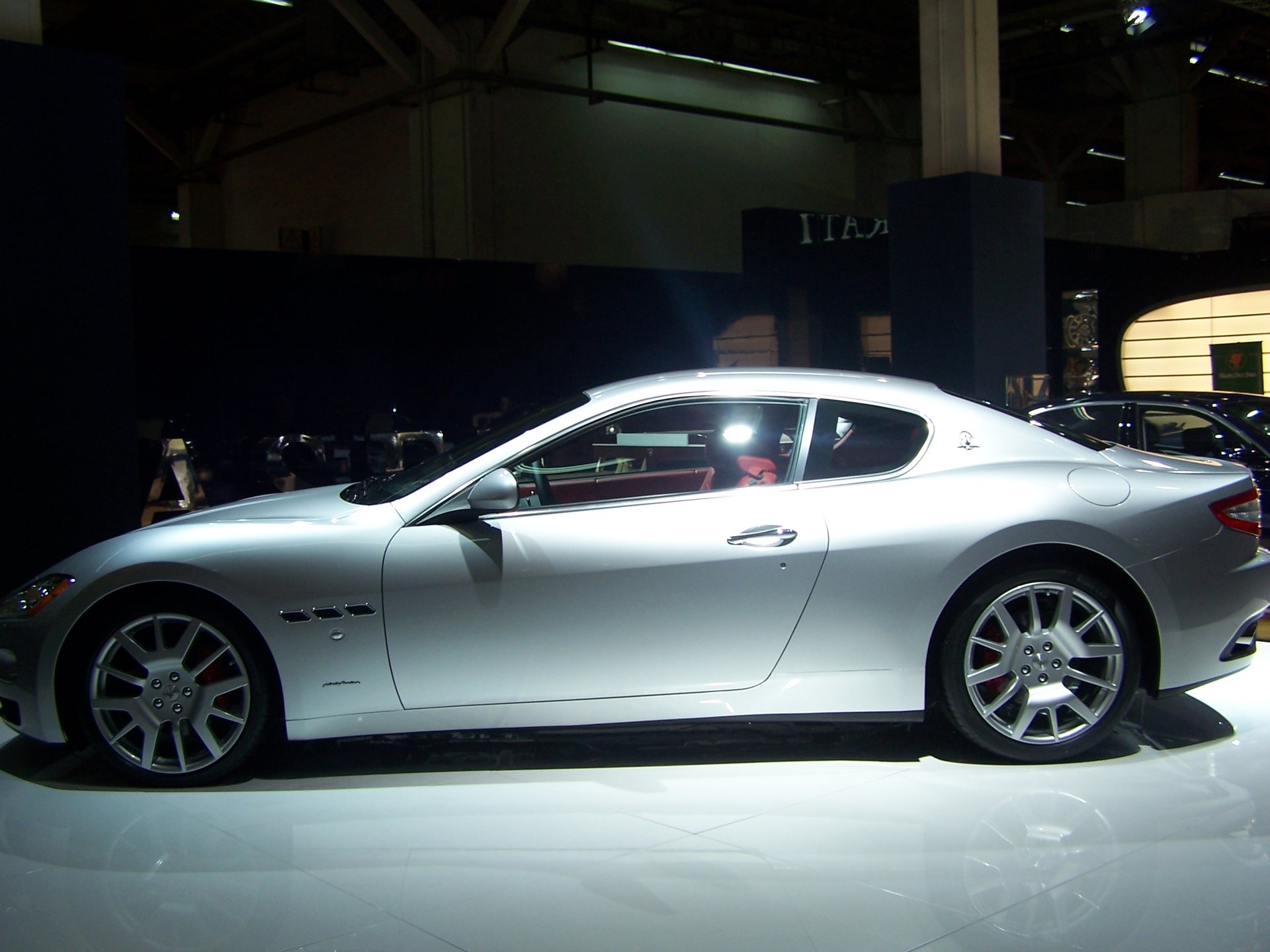 Silver first-generation Maserati GranTurismo coupé in side profile.